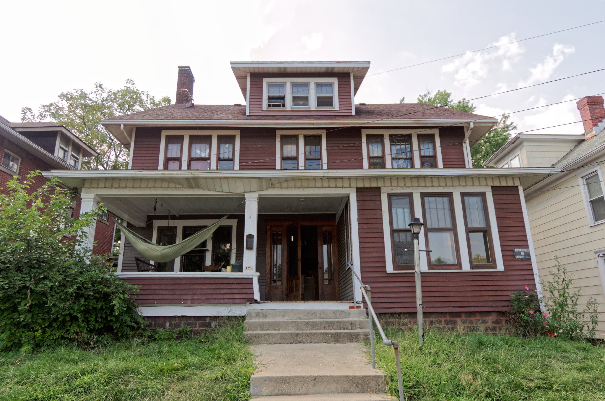 Front of two story red house with white trim