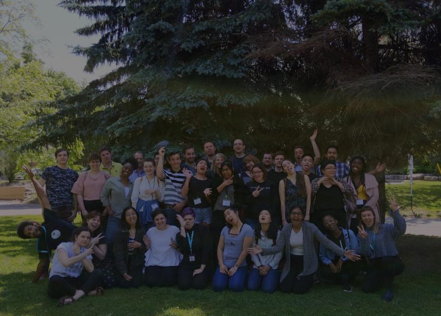 Group of co-opers make silly faces in front of pine trees