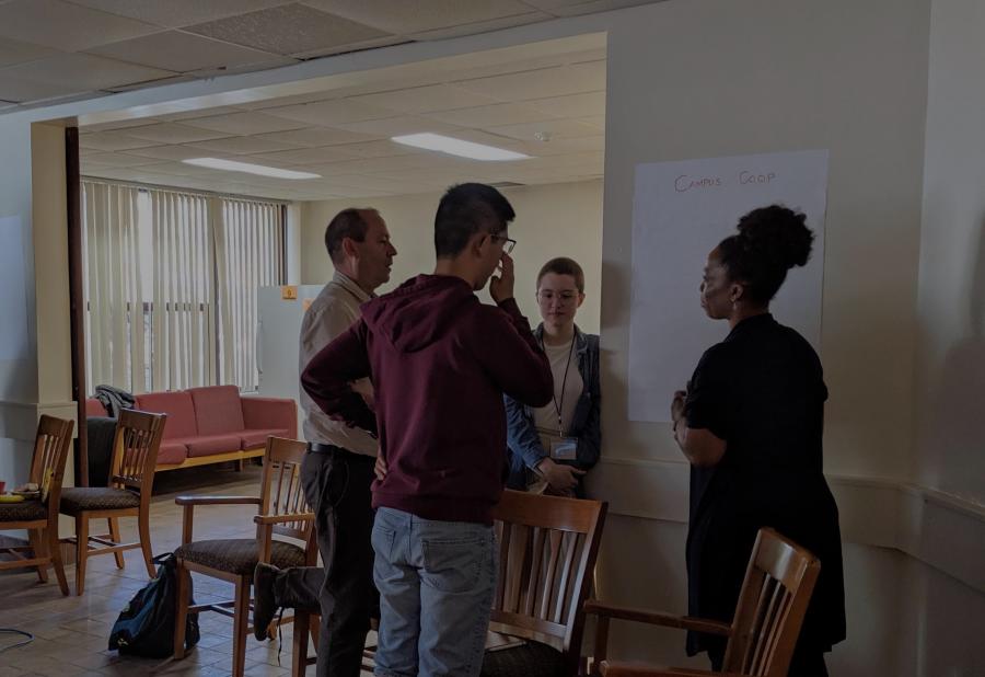 Four co-opers stand in a circle in discussion