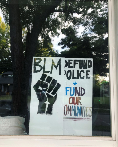 Window sign says BLM, Defund Police + Fund Our Communities