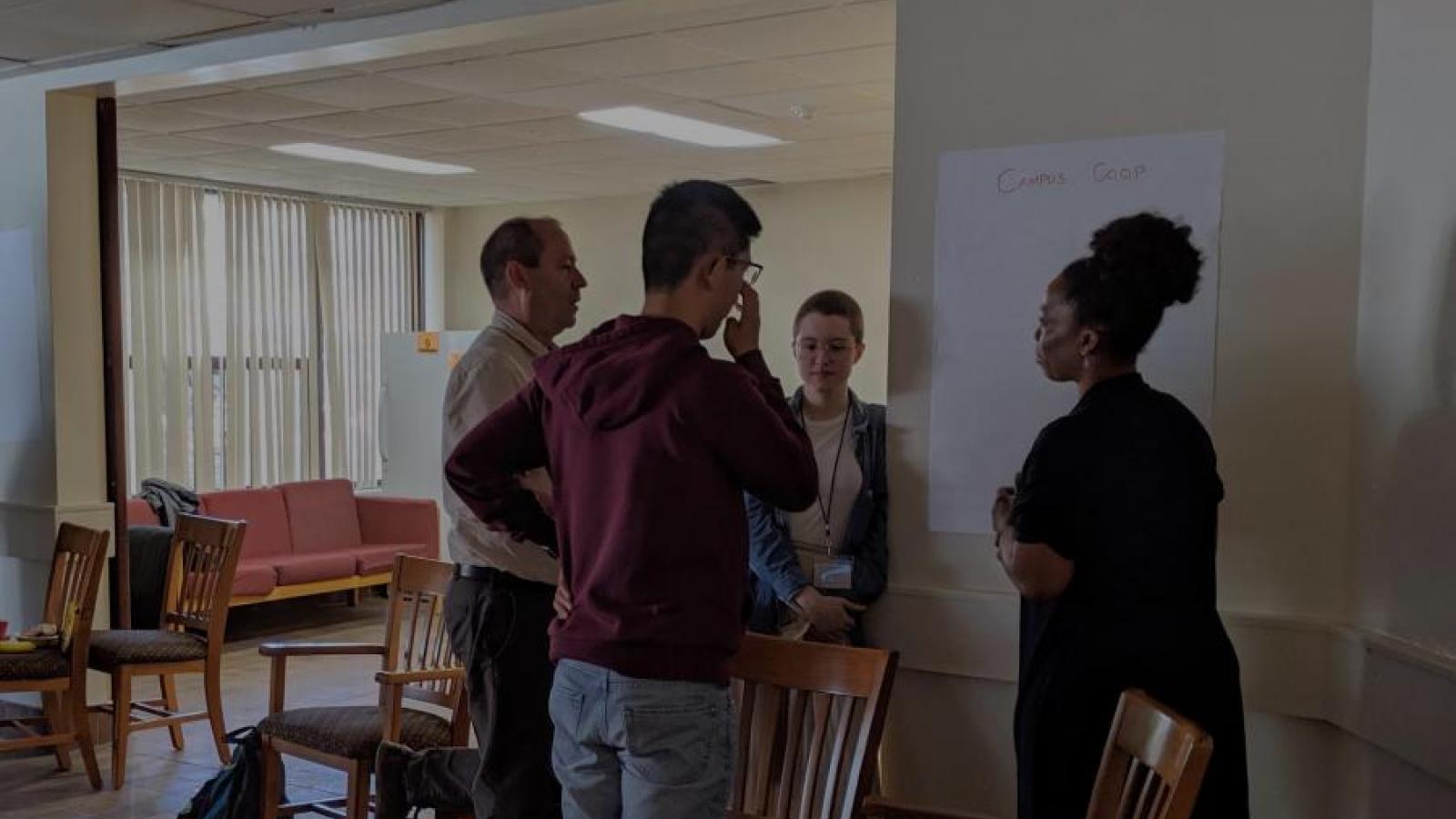 Four co-opers stand in a circle in discussion